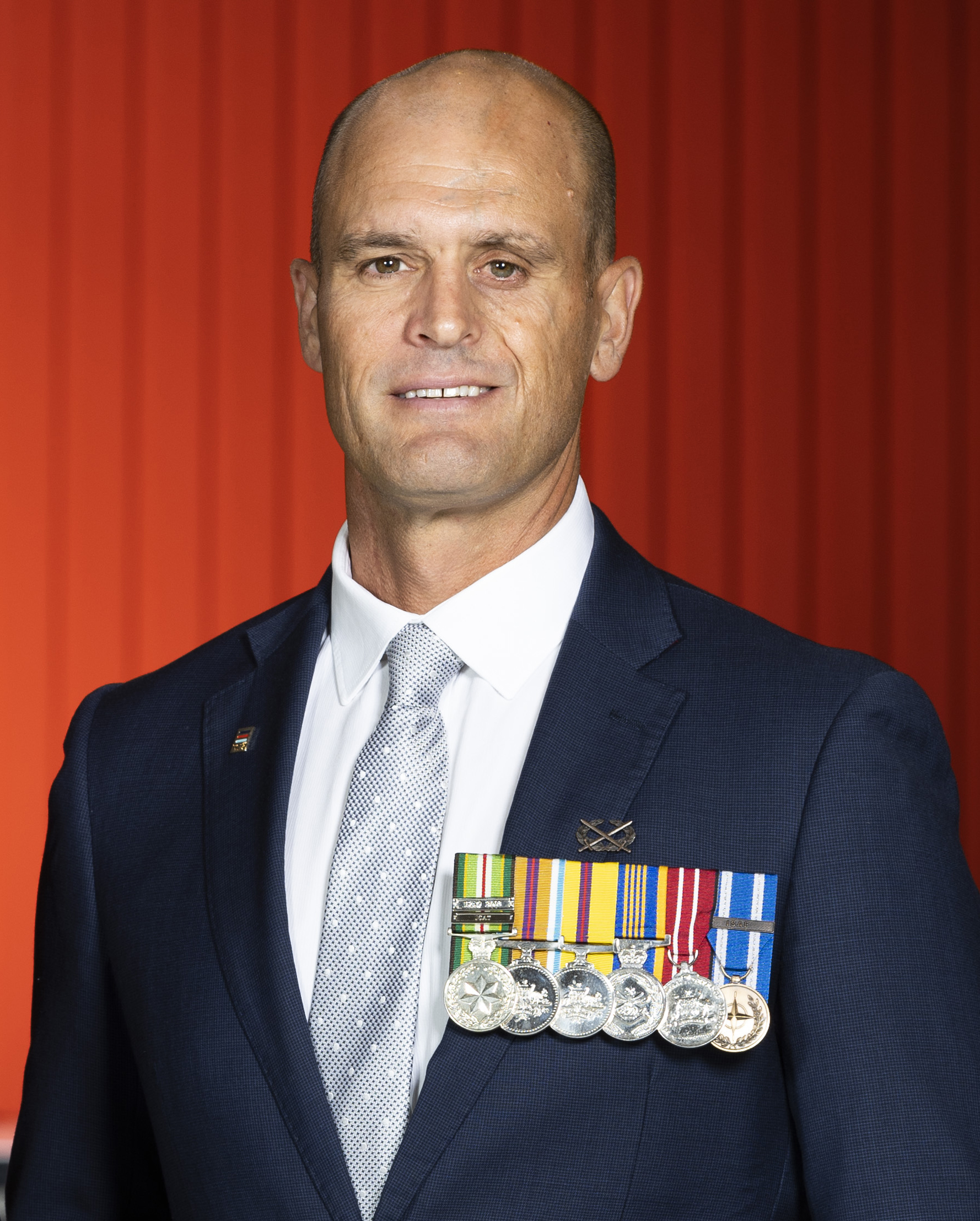 A man standing with his ADF medals displayed