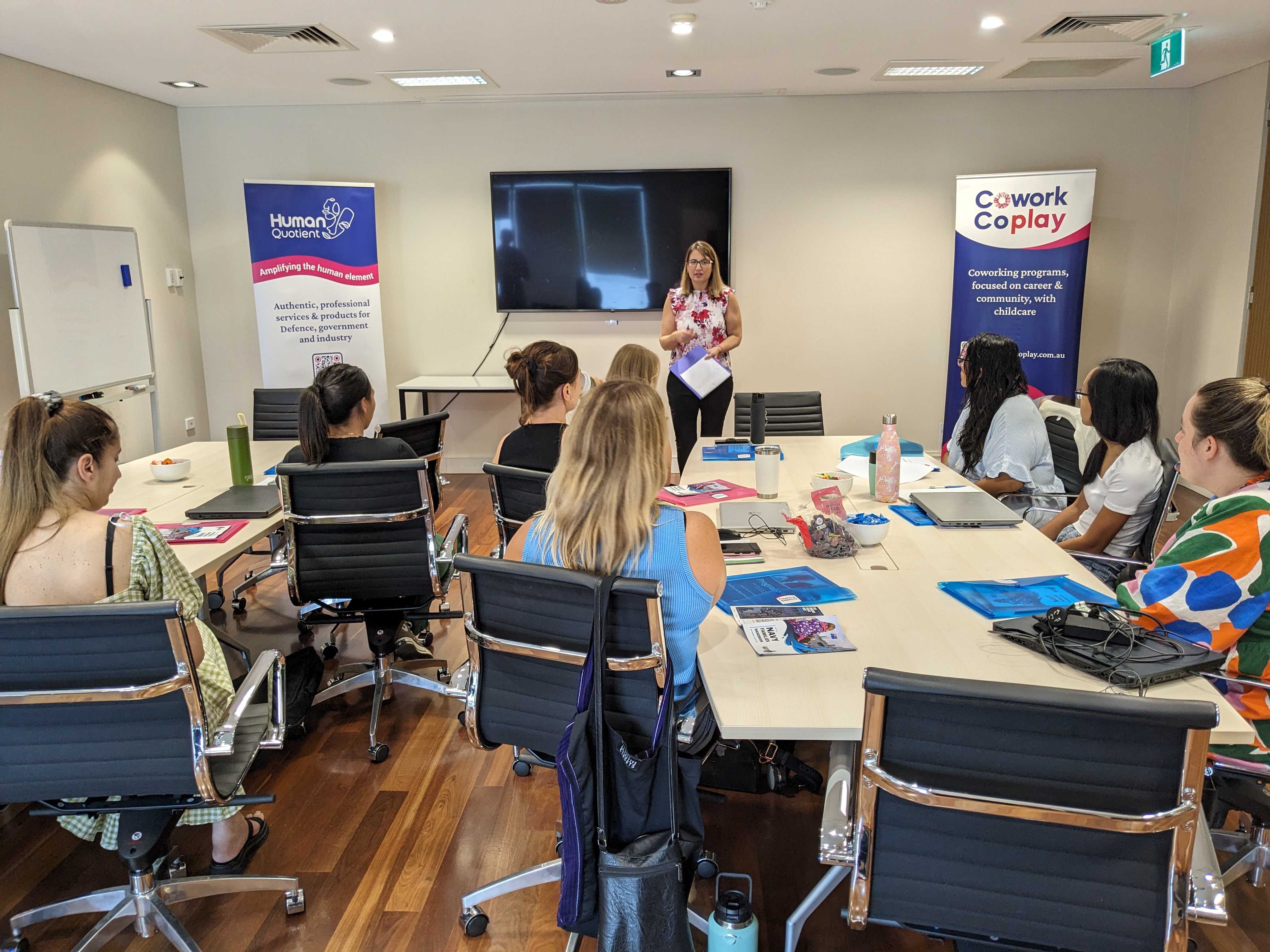 Woman presenting to group sitting at tables