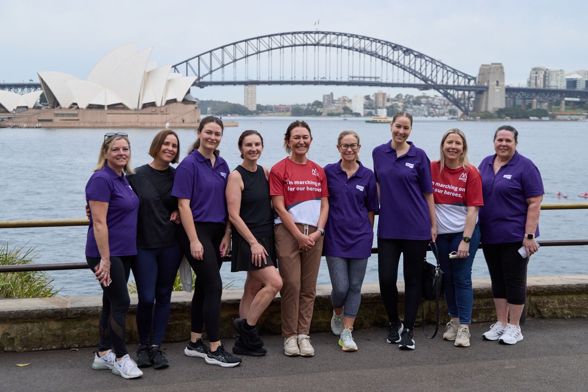 Image of a group of people standing in front of Sydney harbour with the Opera House and bridge behind them