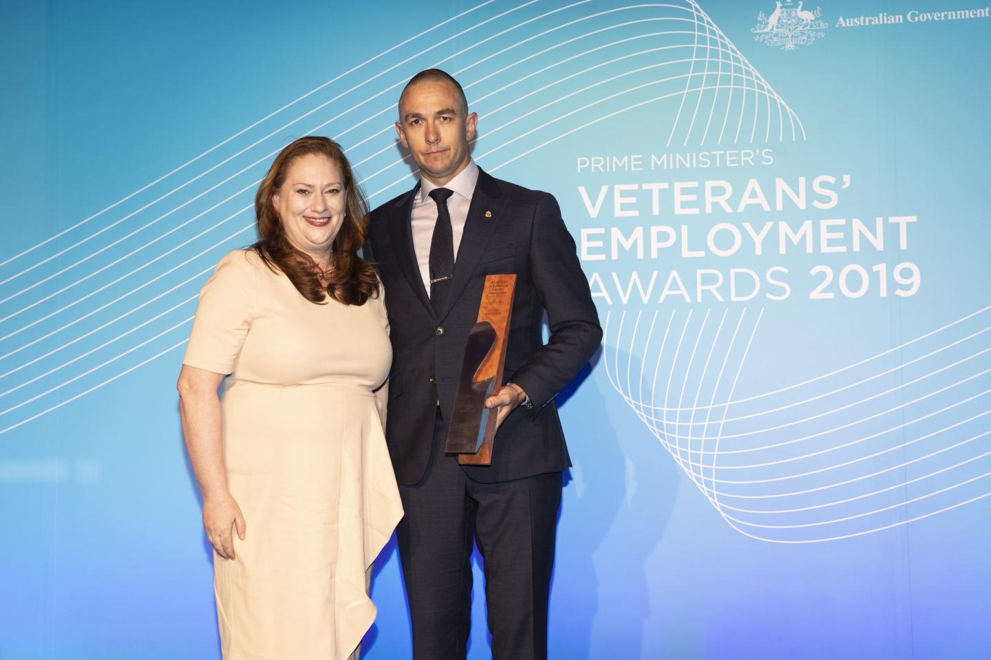 Representative from Ironside Recruitment receiving award trophy.