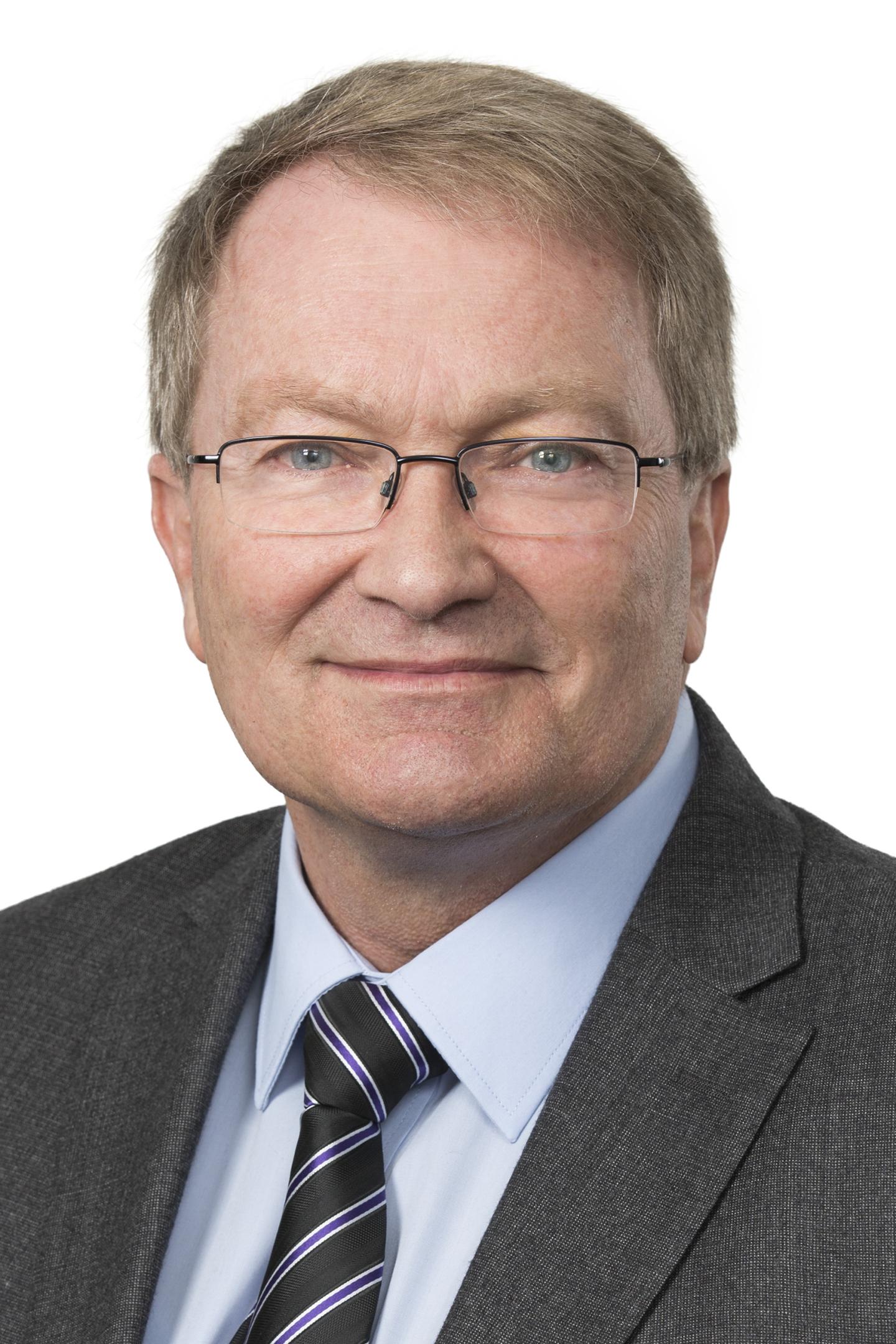 Man in dark suit with glasses