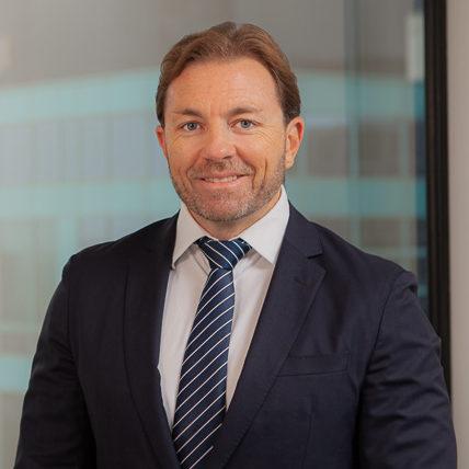 Image of Brett Sangster wearing formal business attire.