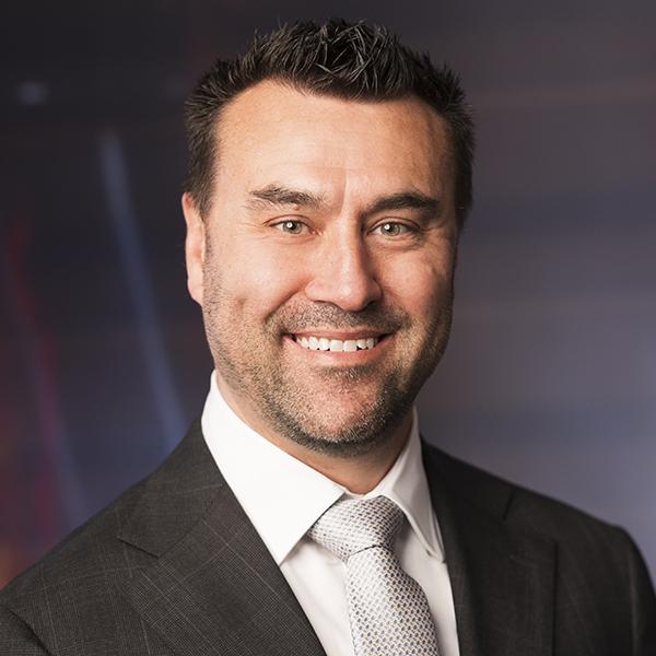 Headshot of a smiling dark-haired man
