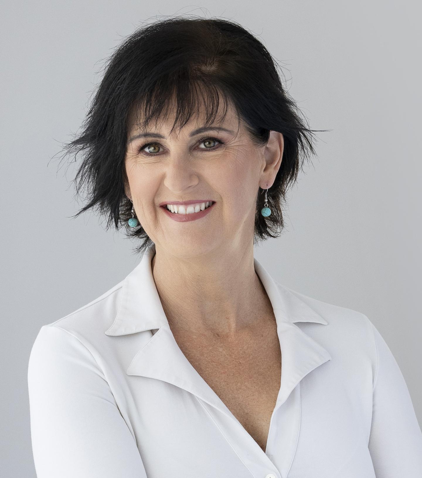 Dark haired woman in white shirt smiling