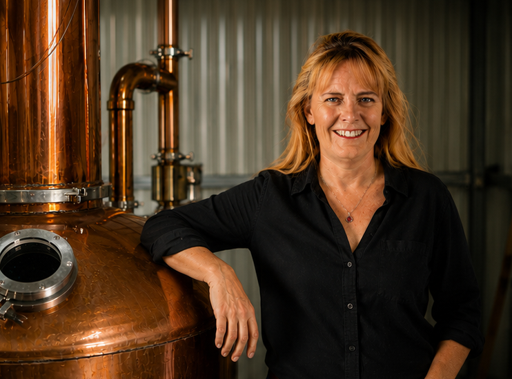 Woman in black shirt standing next to distiller