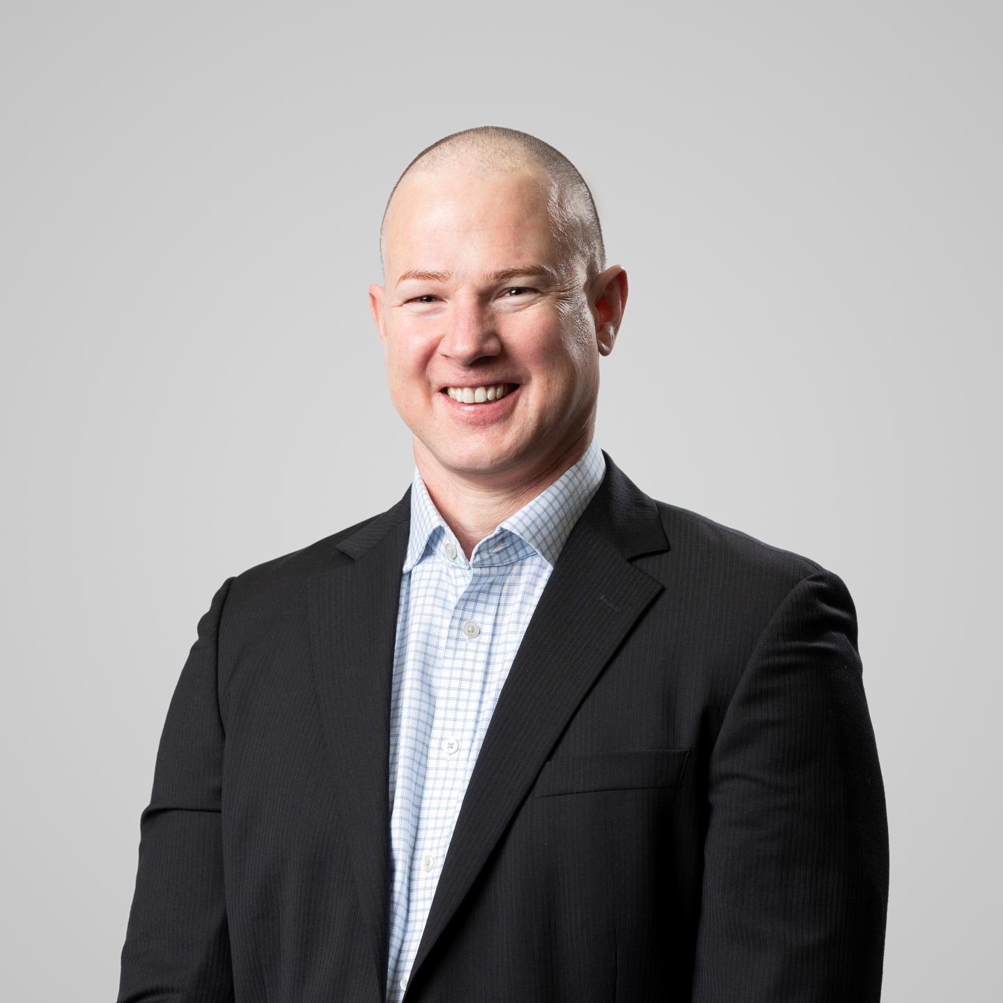 Man in dark suit jacket smiling