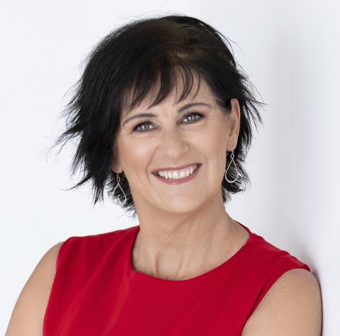 Headshot of smiling dark haired woman in red top