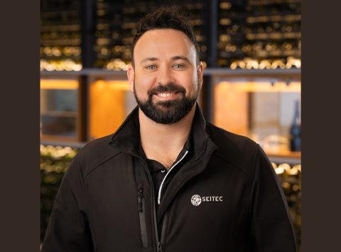 Headshot of dark haired man smiling