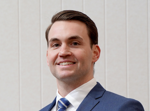 Headshot of smiling dark haired man